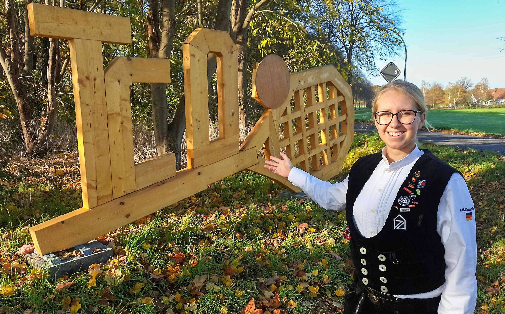 Katja Wiesenmüller mit selbst gebautem Holzemblem. Foto: Tobias Woelki