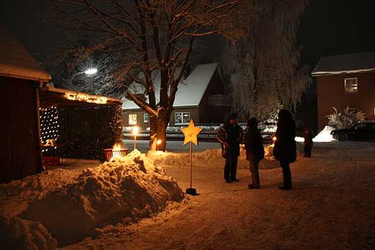 Vor beleuchteten Carports und Garagen finden die Veranstaltungen des lebendigen Adventskalenders statt